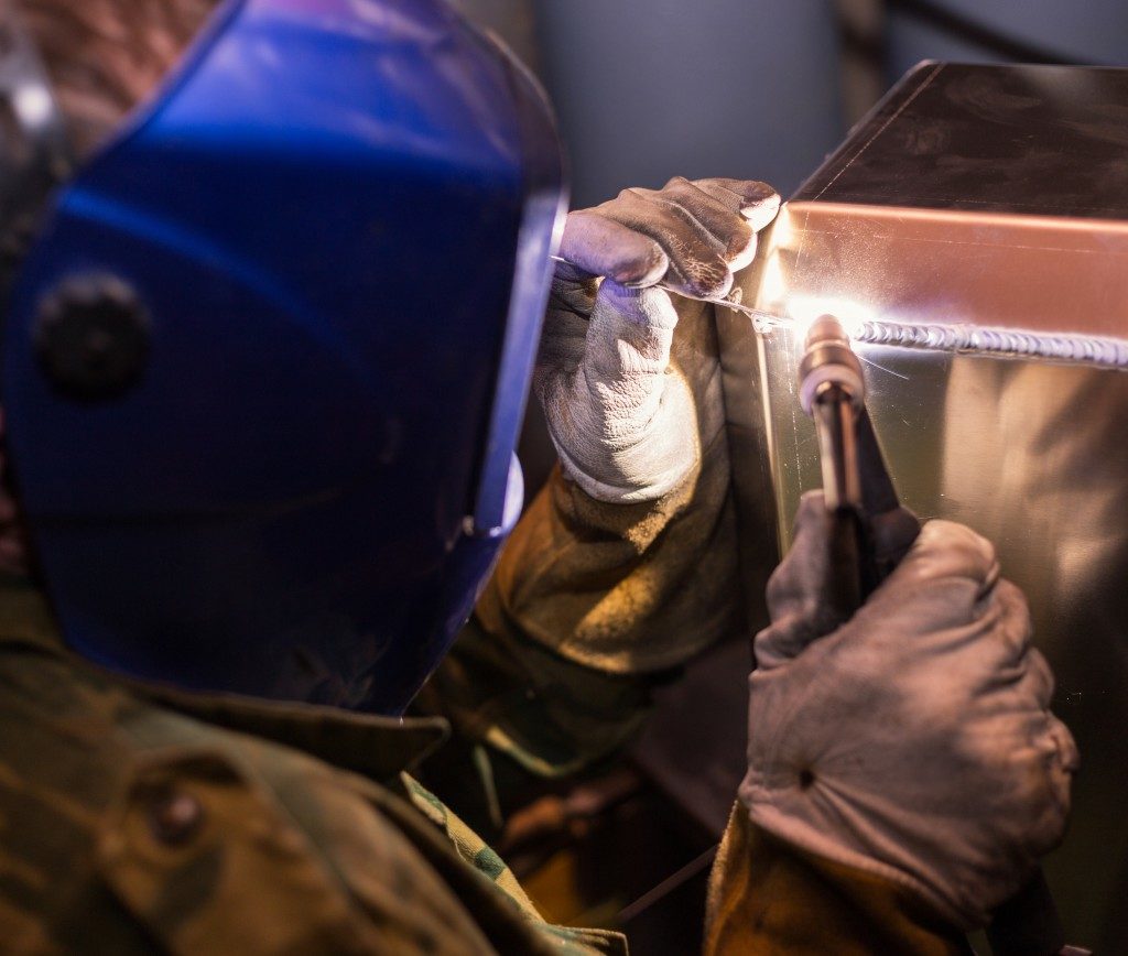 close up of worker welding metal