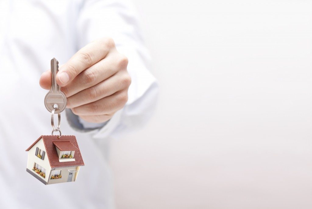 handing house keys with home keychain