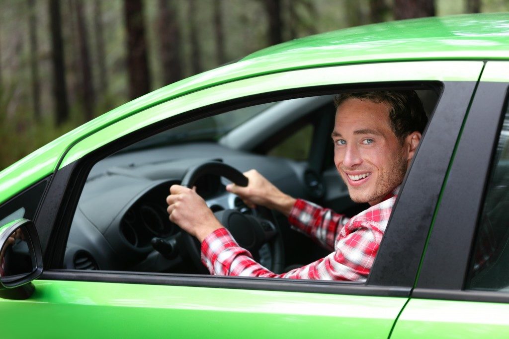 man driving his green car