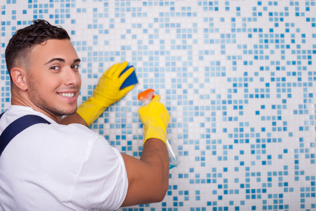 man cleaning bathroom wall