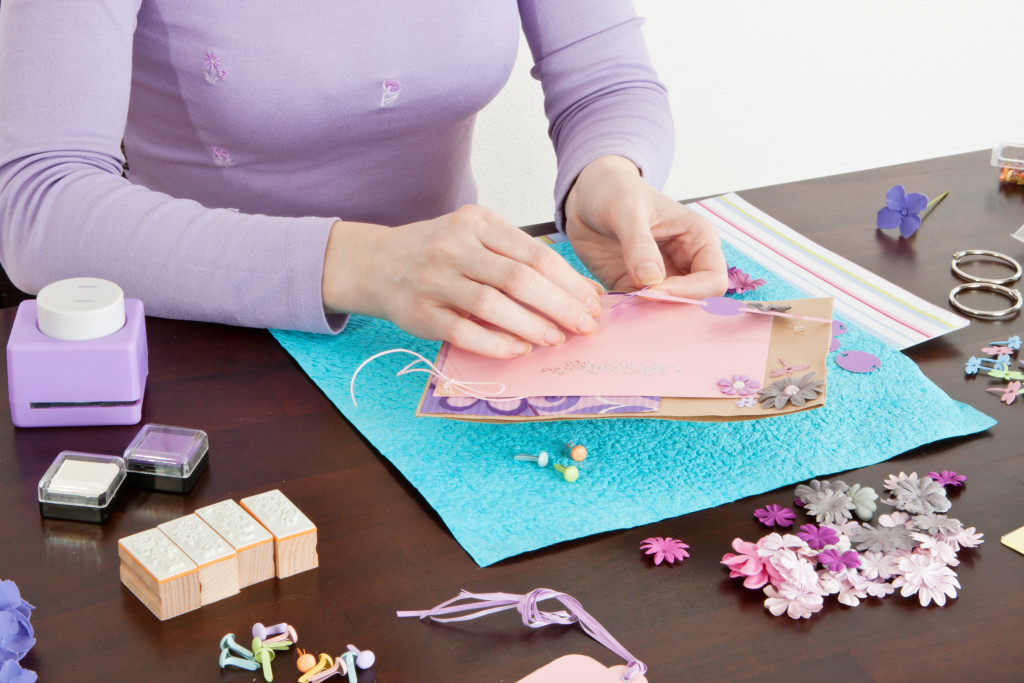a woman making a scrapbook with materials on the desk